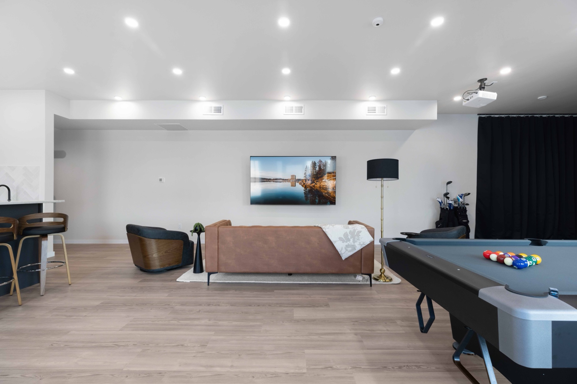 Clubhouse lounge with pool table, leather seating, and golf simulator