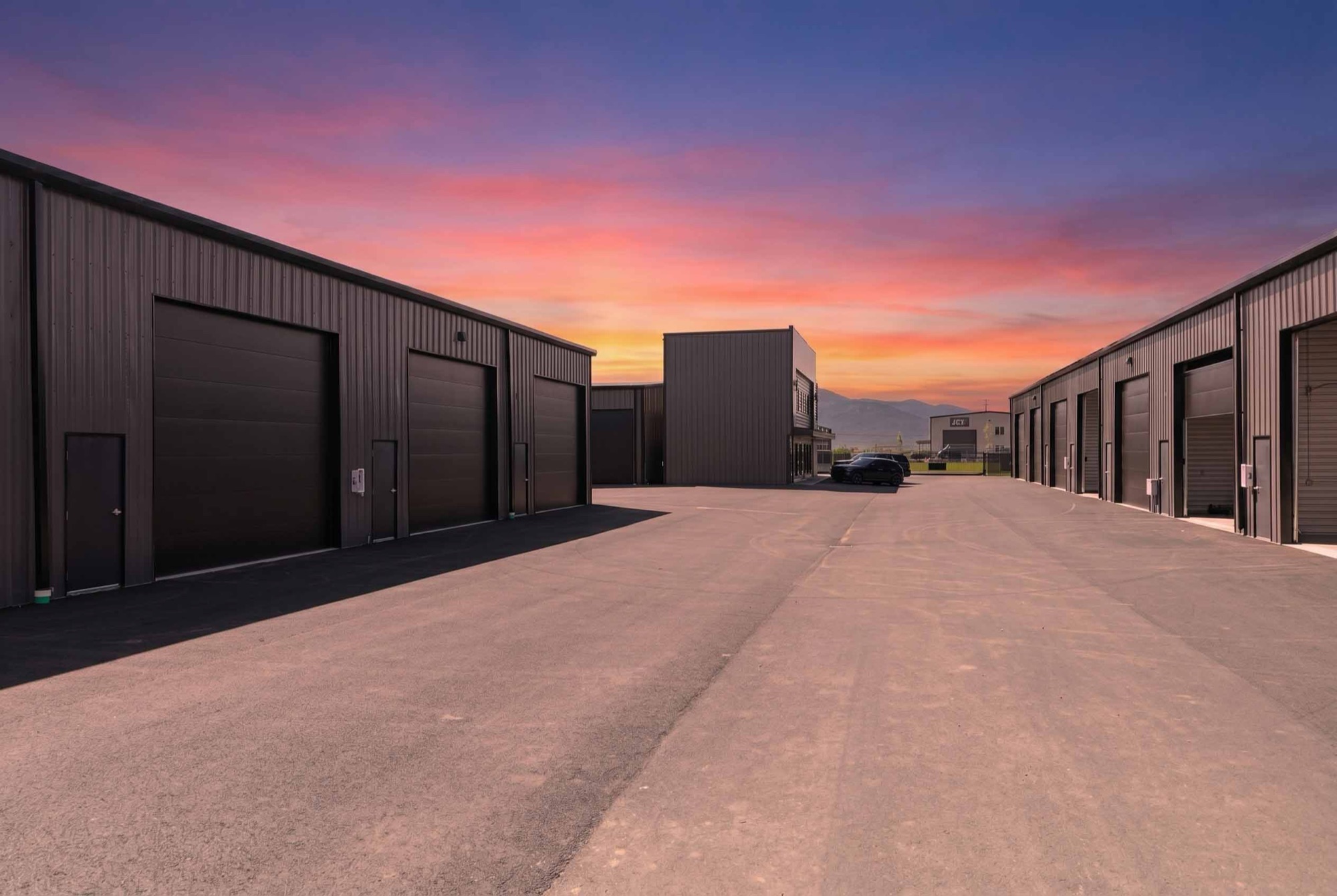Wide drive lanes between garage condo buildings at sunset