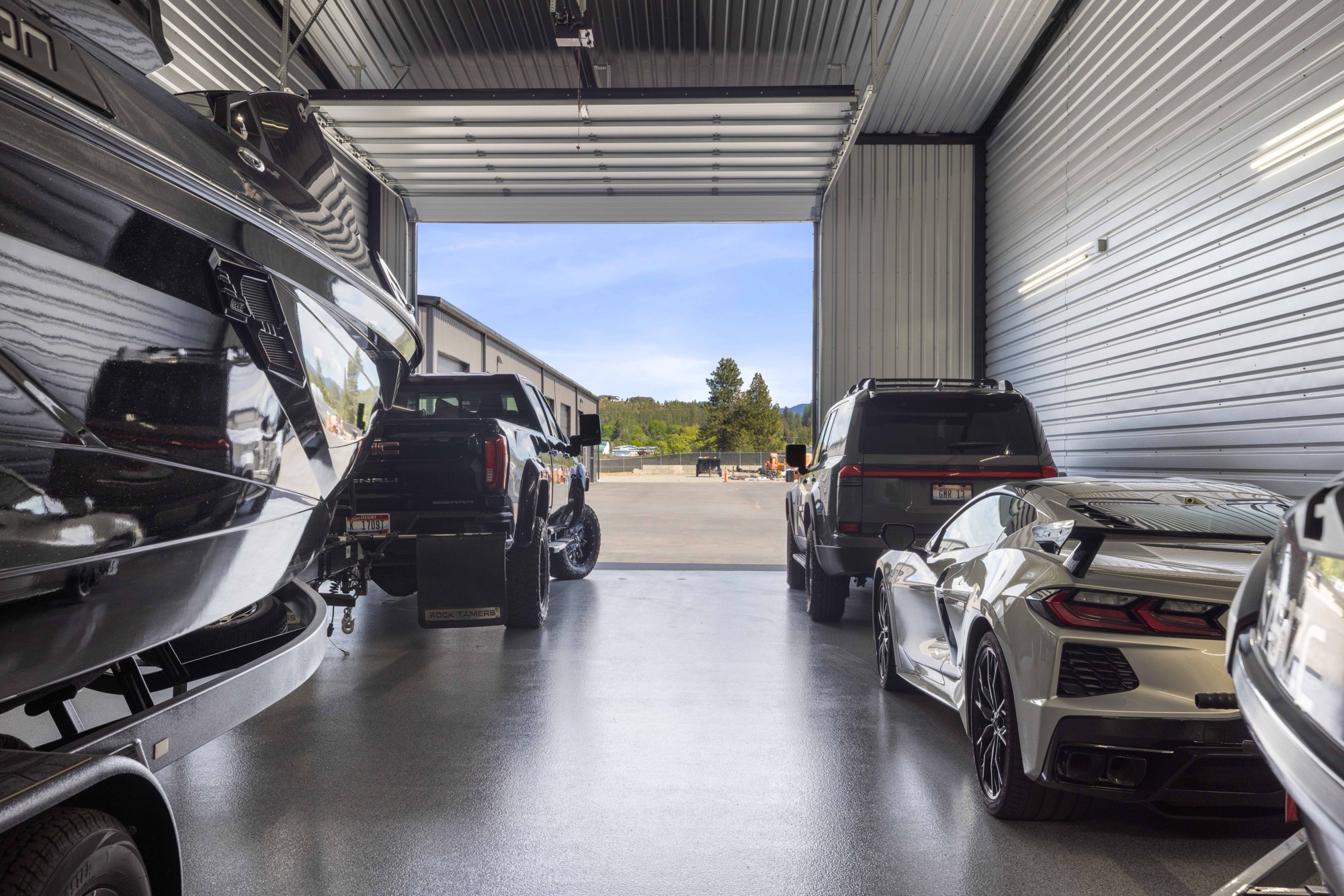 Boat and vehicles inside a garage condo looking out the 16 by 14 foot door