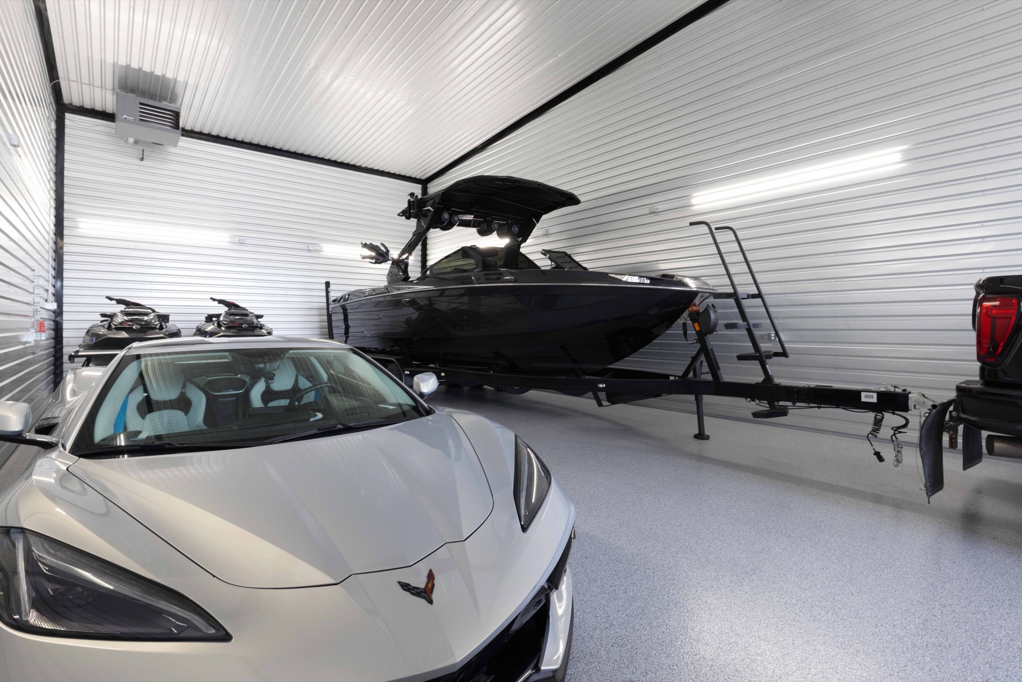 Boat and Corvette parked inside a Locked & Loaded garage condo