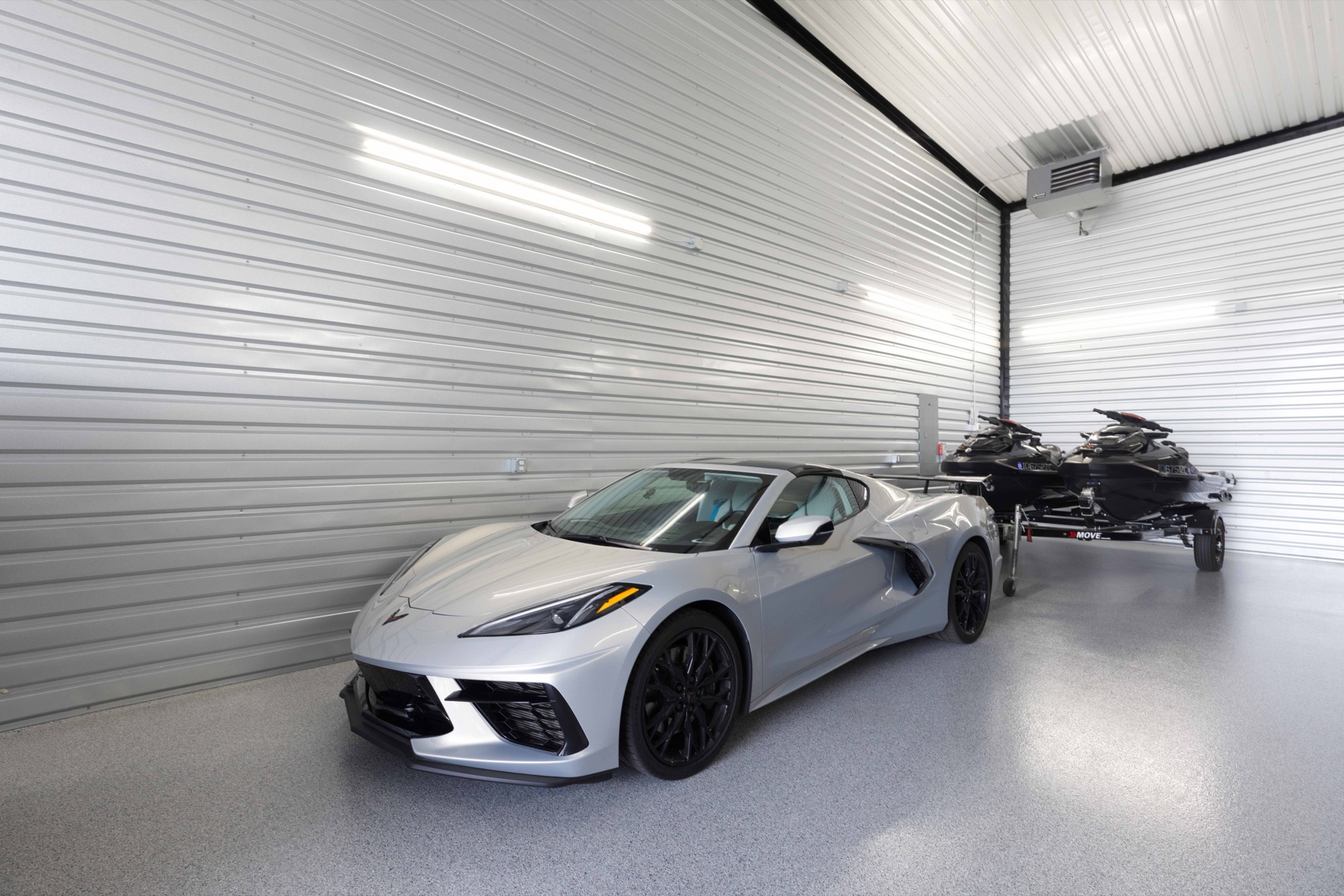Corvette and snowmobiles stored inside a garage condo